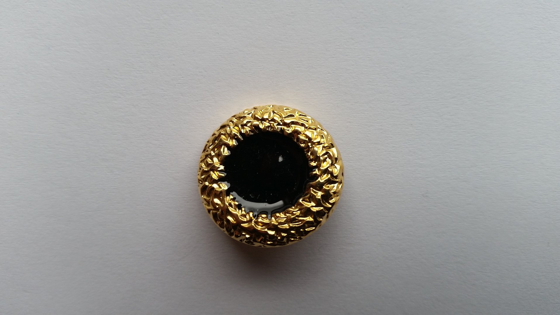 Goldener Metallknopf im Durchmesser von 22 mm